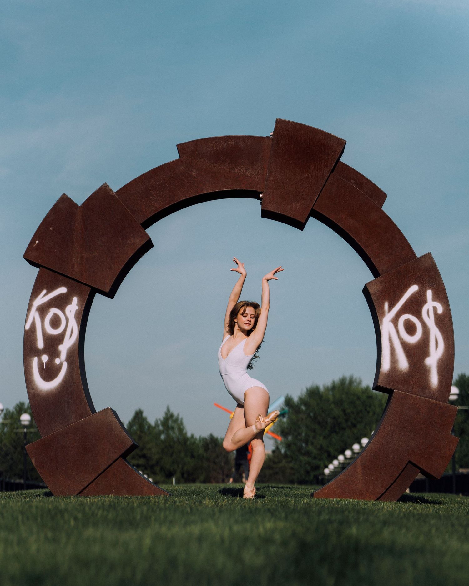 Indianapolis ballet photography session featuring a petite dancer balancing en pointe in an art sculpture