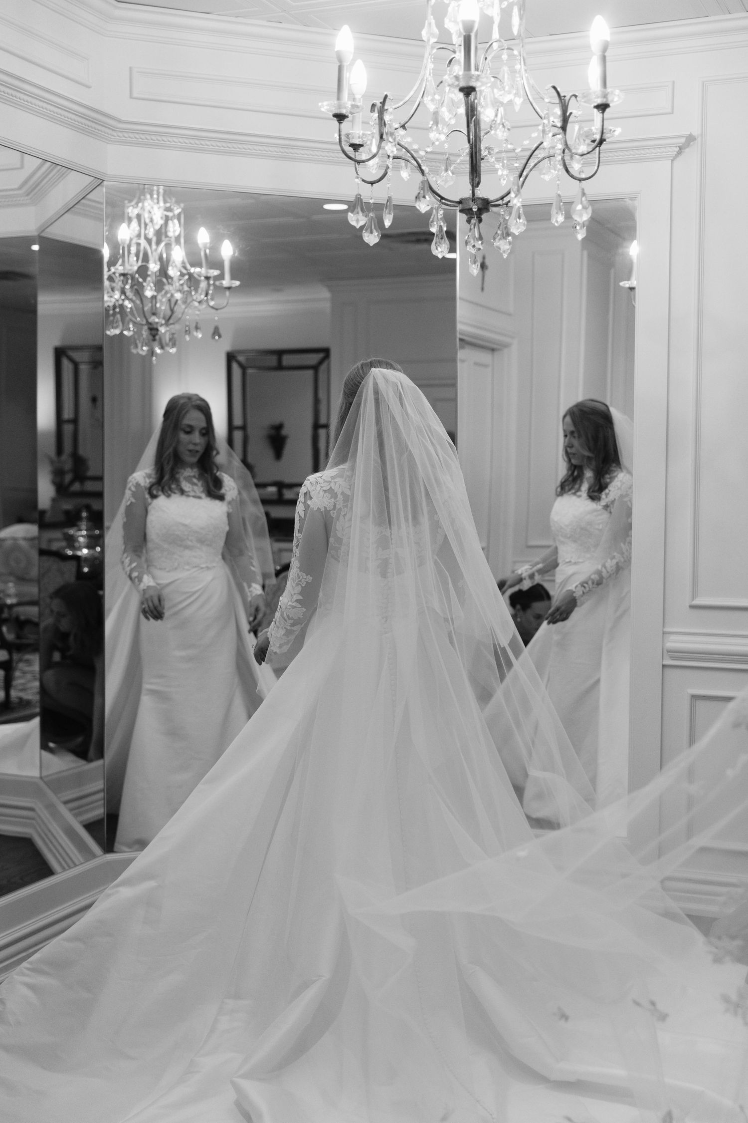 A black and white photo series showing a bride in an elegant wedding gown with flowing cathedral veil in a grand room.
