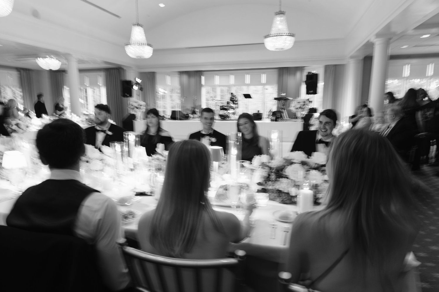 Wedding reception venue decorated in white with tables and chairs set up for a formal celebration.