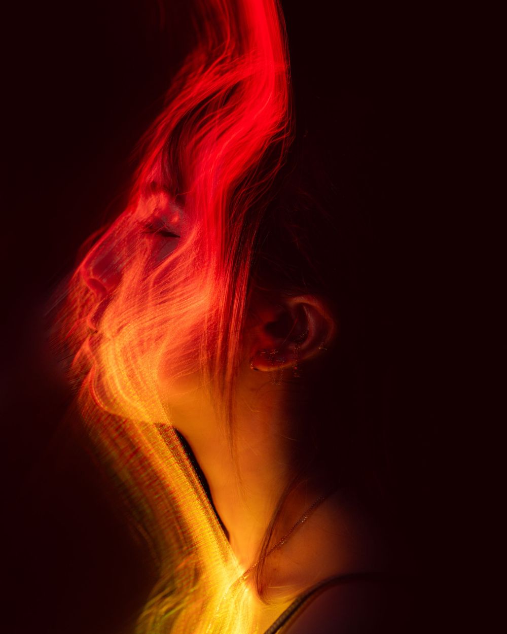Peinture lumineuse abstraite représentant des motifs fluides rouges et orange semblables à des flammes sur fond sombre. Florent Vause