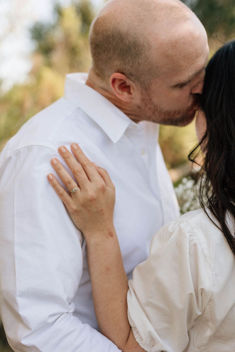 Detailed 35mm film photo of the engagement ring as the couple holds hands in the Ojai light.