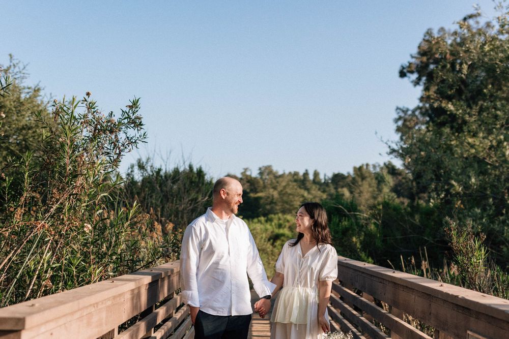 Wide-angle Ojai film photography showcasing the couple in the vast, breezy meadow landscape.