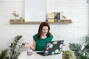 woman business coach Seattle, WA branding lifestyle sitting at desk on zoom call with client on laptop