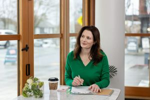 woman business coach Seattle, WA branding lifestyle sitting at cafe table working and preparing presentation notes