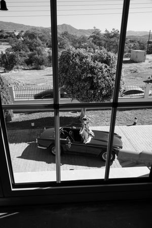 Window view showing a mountainous landscape with homes visible in the distance.