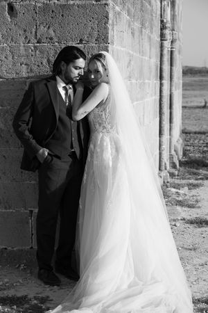 A romantic black and white wedding photograph sequence showing the couple in an elegant stone building setting.
