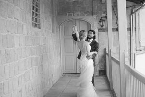 Sunlit stone hallway with arched doorways showcases historic Mediterranean architectural details and shadows.
