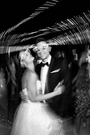 Artistic long exposure shot of a wedding dance with light trails creating a tunnel effect.
