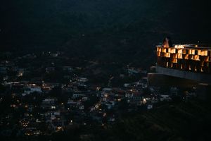 A sequence of nighttime cityscape images showing illuminated buildings and lights scattered across a dark mountainous terrain.