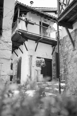 A rustic balcony view of a traditional stone building captured in dramatic black and white.
