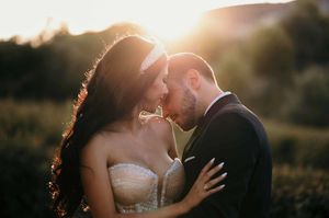 Intimate wedding couple portraits at sunset creating silhouettes against golden light.