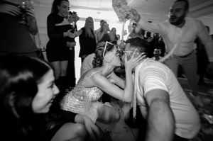 Black and white photo showing people dancing and celebrating at what appears to be a lively party or gathering.
