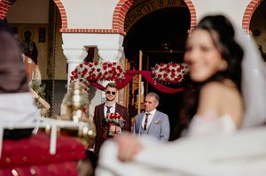 A wedding ceremony moment with red and white decor elements in an elegant indoor venue.