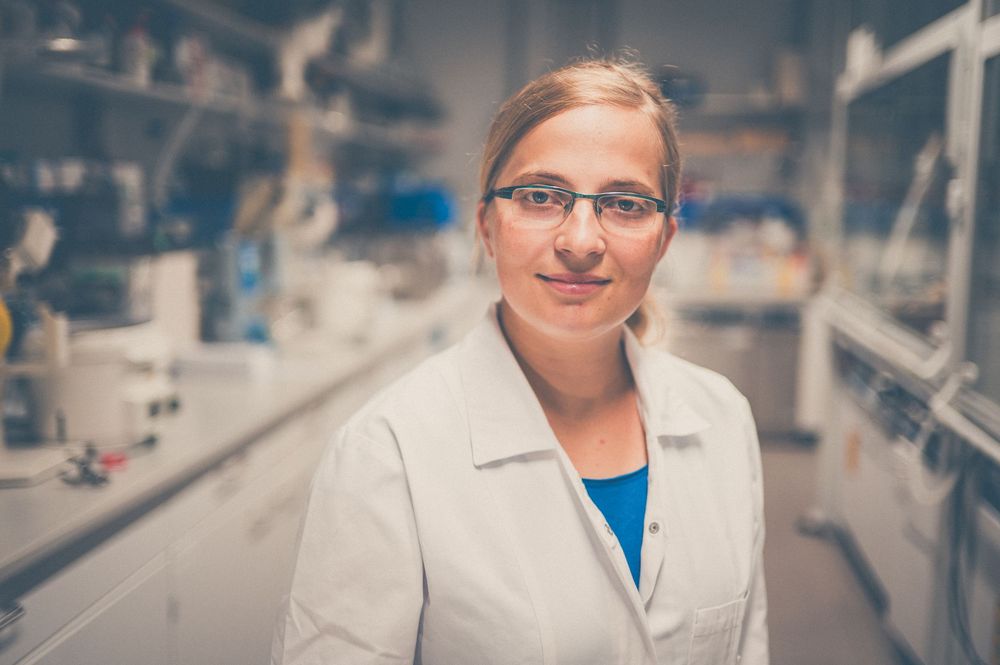 Scientists in white lab coats work in a modern research laboratory with specialized equipment and instruments.
