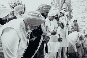 A black and white photograph showing participants in traditional ceremonies and cultural dress.