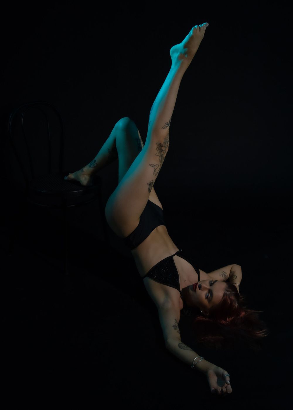 Moody portrait series with teal accent lighting creating artistic shadows on dark background.