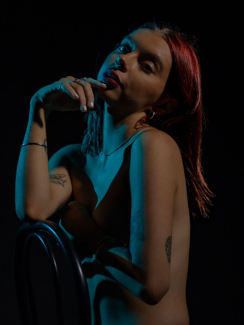 Atmospheric portrait bathed in blue lighting creating mysterious mood against dark background.