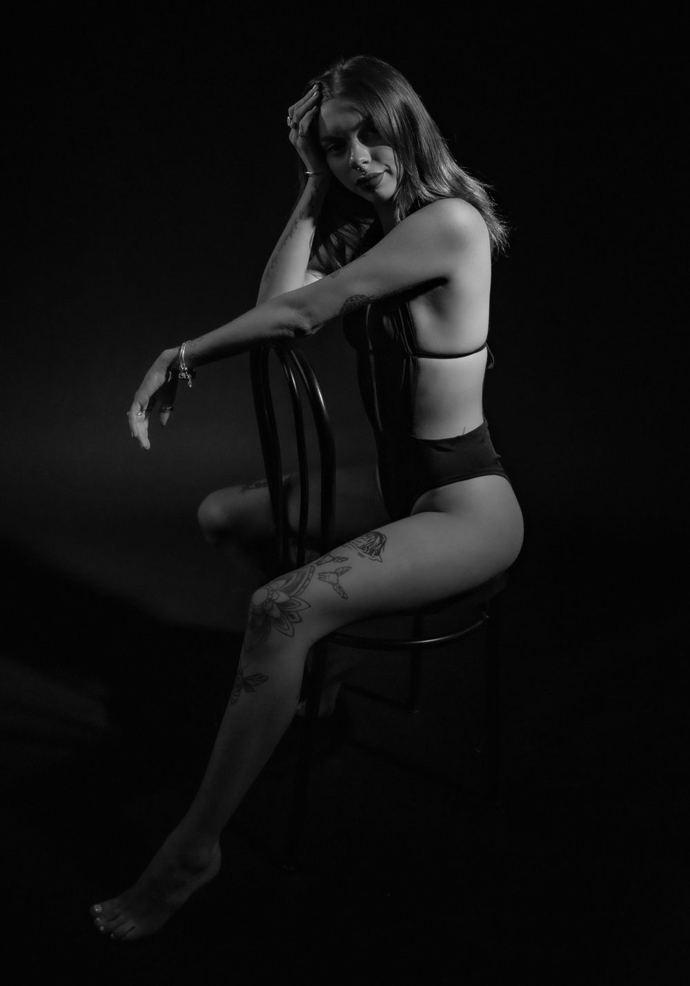 Low key black and white portrait showing graceful poses in dramatic lighting.