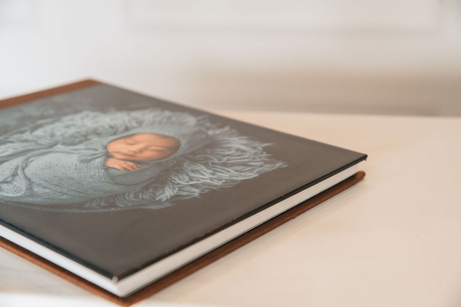 Professional photo album laying flat on white surface showing high-quality print finish.
