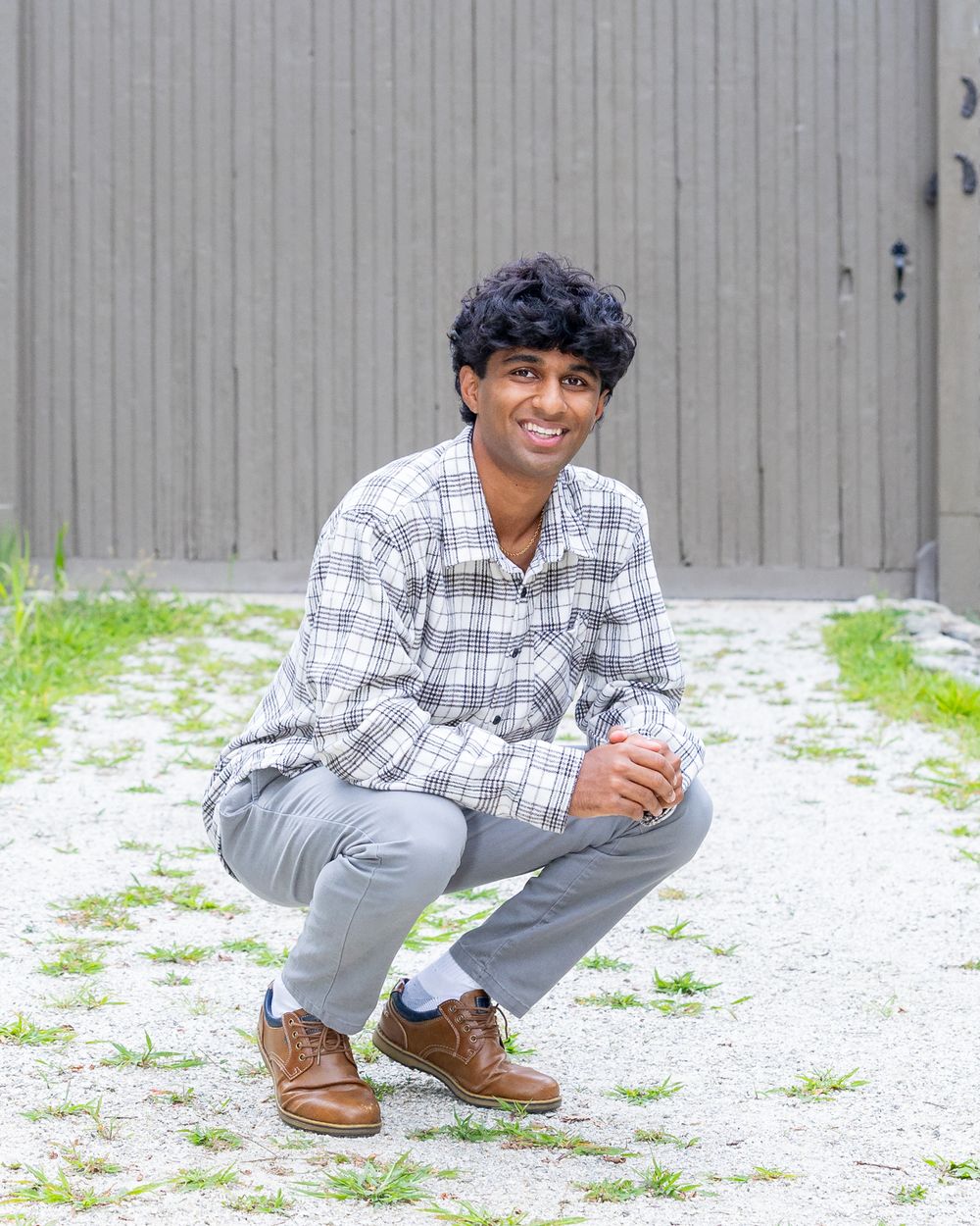 A high school senior poses by a barn at Hartwell Tavern in Lincoln, MA  in a yearbook portrait session with Lisa West Photography. Concord