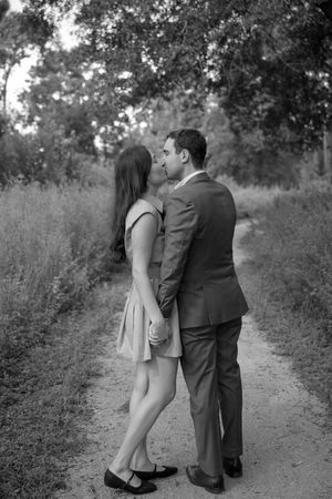 Couple walking together on a romantic path through nature in black and white.