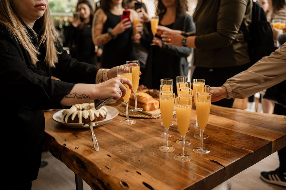 Champagne glasses and appetizers arranged on a rustic wooden table at an event.