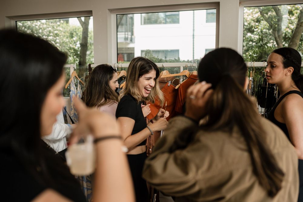 A crowded indoor social event with people gathered in conversation.