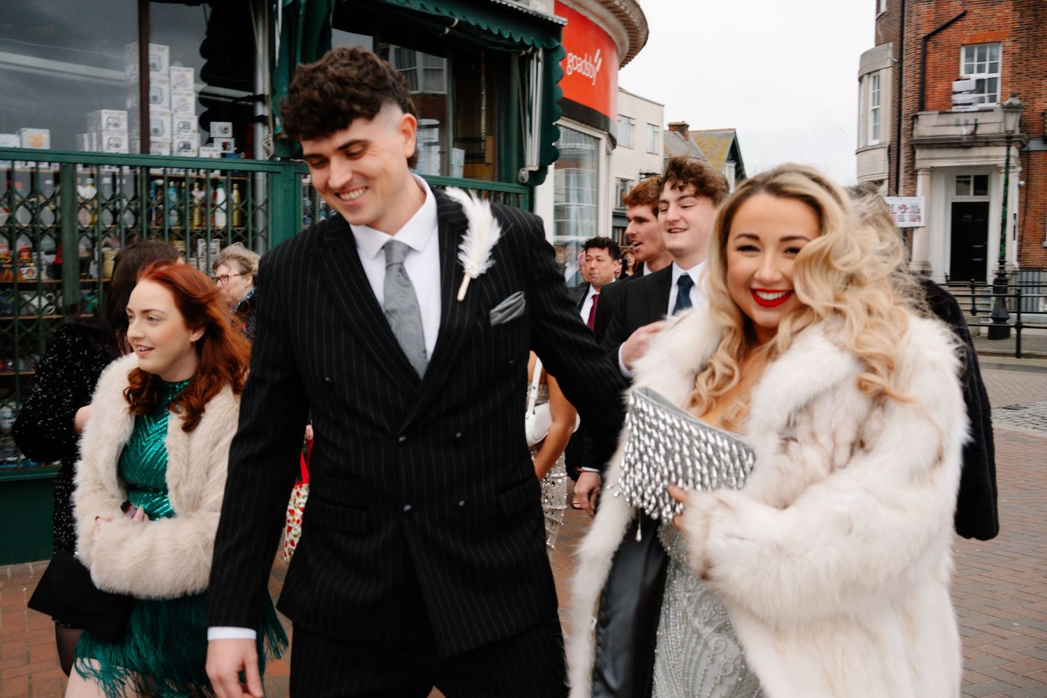 Bride and groom walking together in Weymouth highstreet near the promenade during their New Year’s Eve wedding