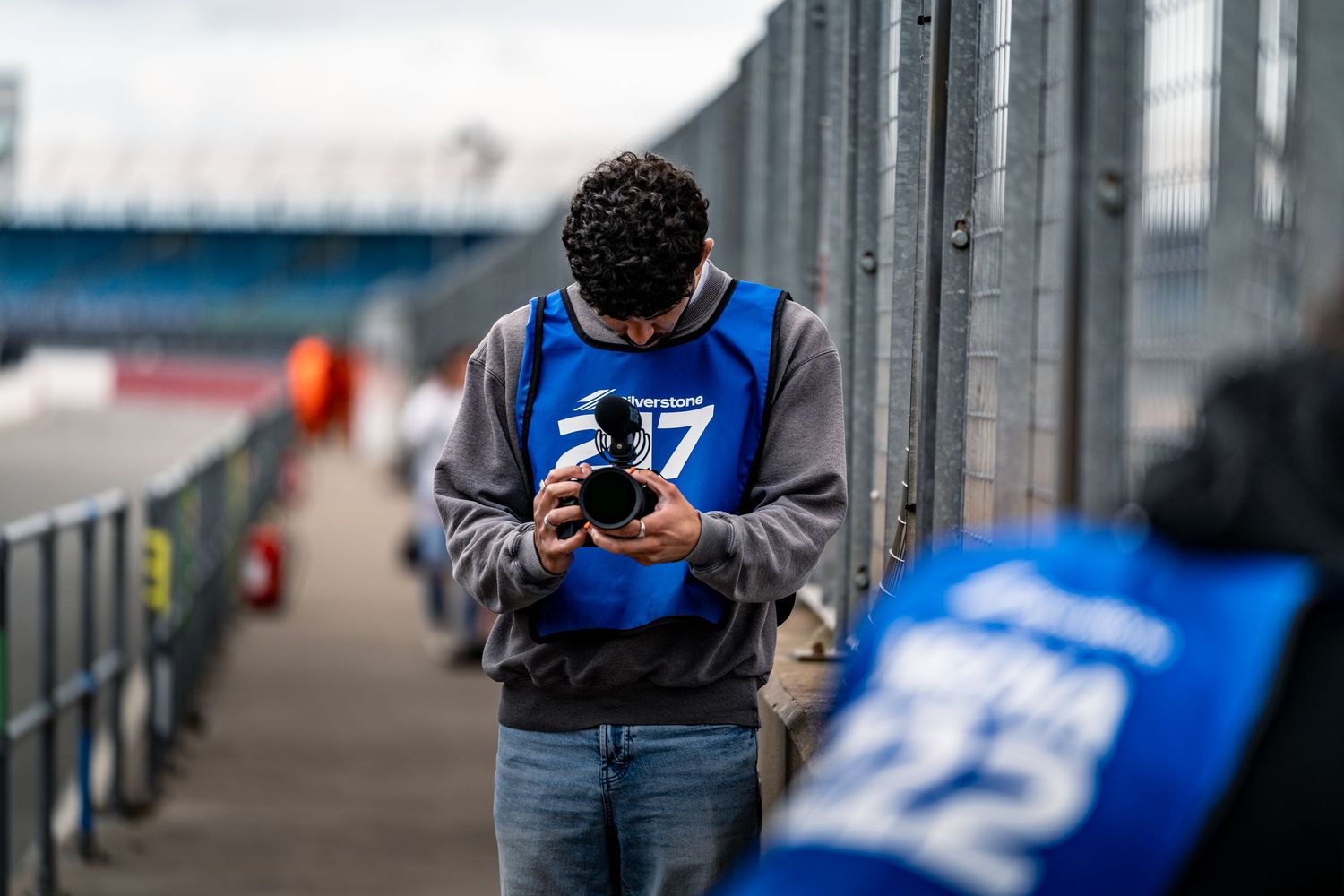 Racing pit crew members in blue uniforms preparing for competition.