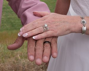 Close-up of hands joining together during wedding ceremony.