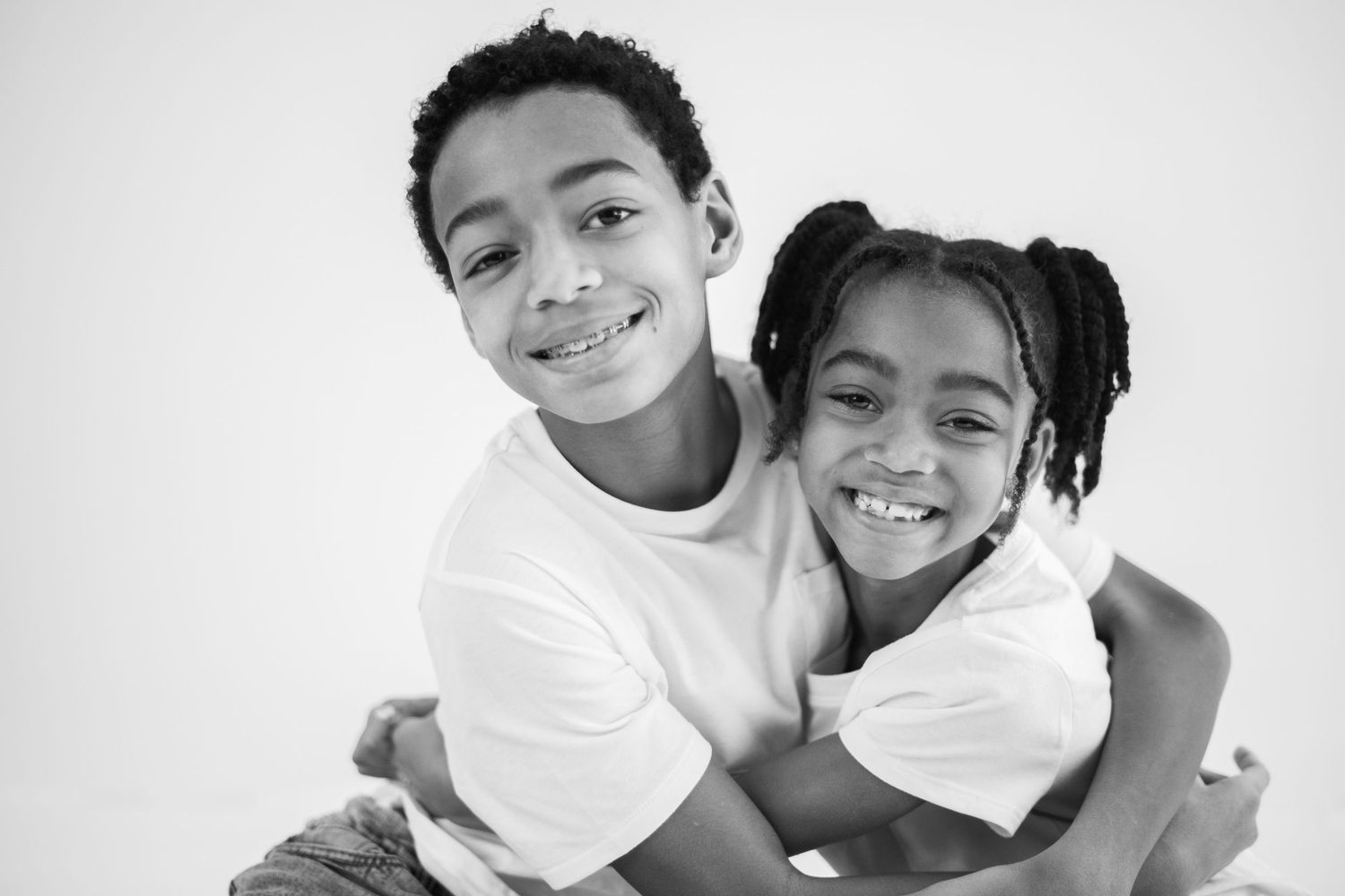 A black and white photo collage showing people embracing and smiling together in candid moments.