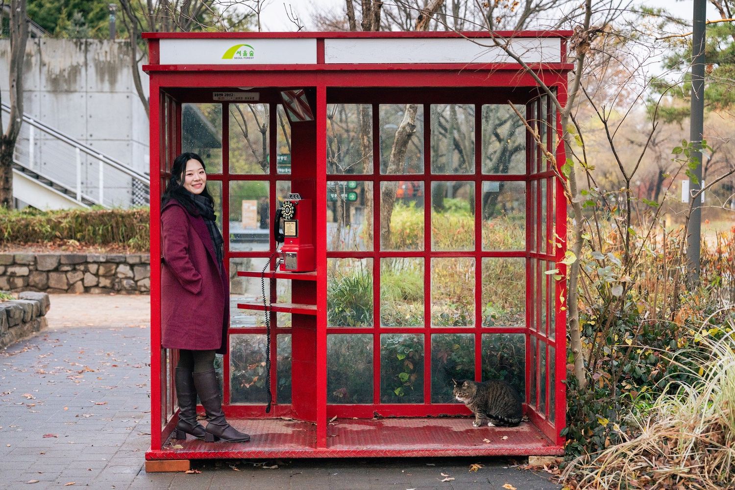 A series of red metal structures or frames arranged in a row along an outdoor path or walkway.