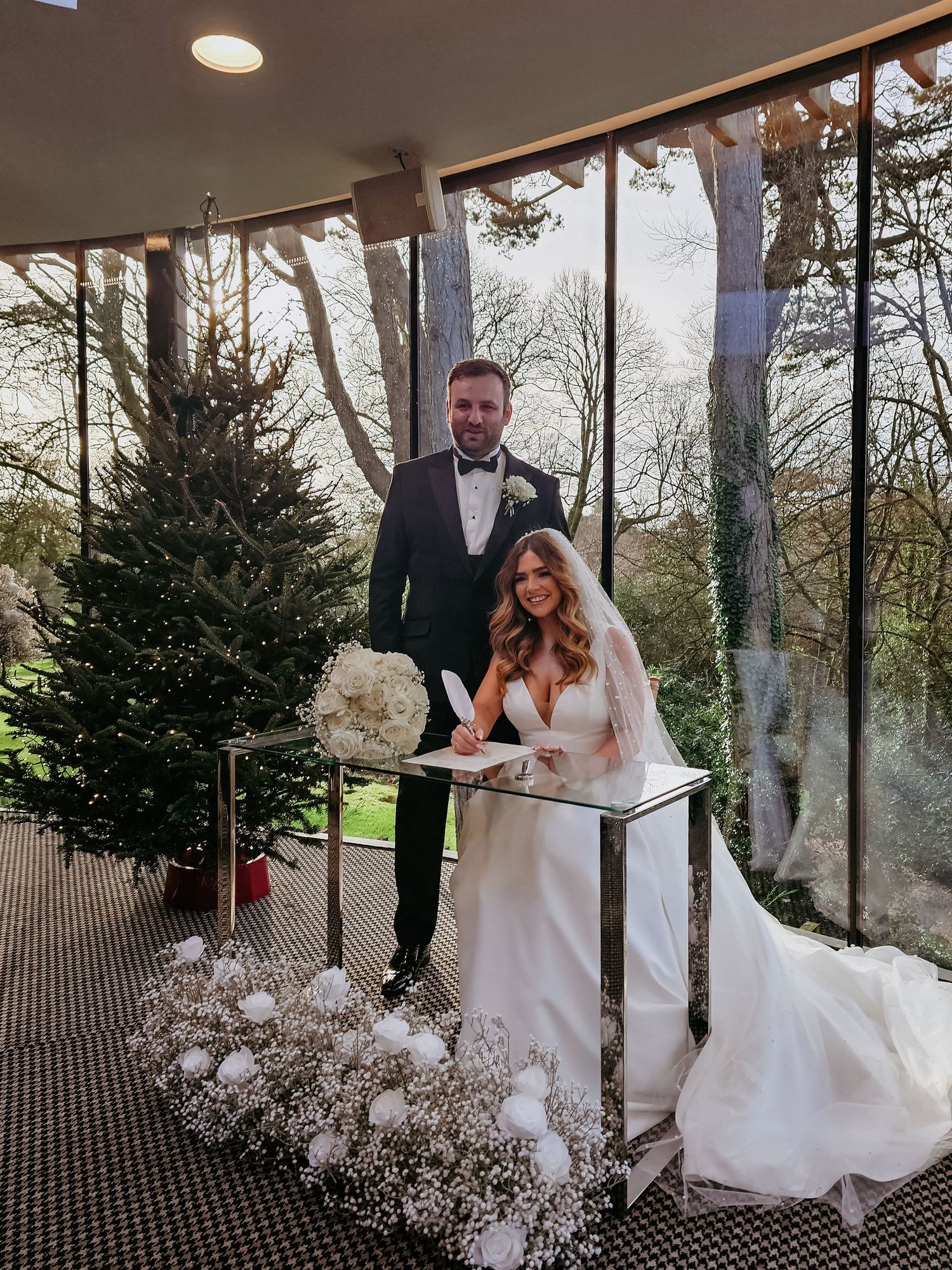 A romantic wedding couple shares intimate moments in a series of photos under a glass ceiling with baby's breath decor.