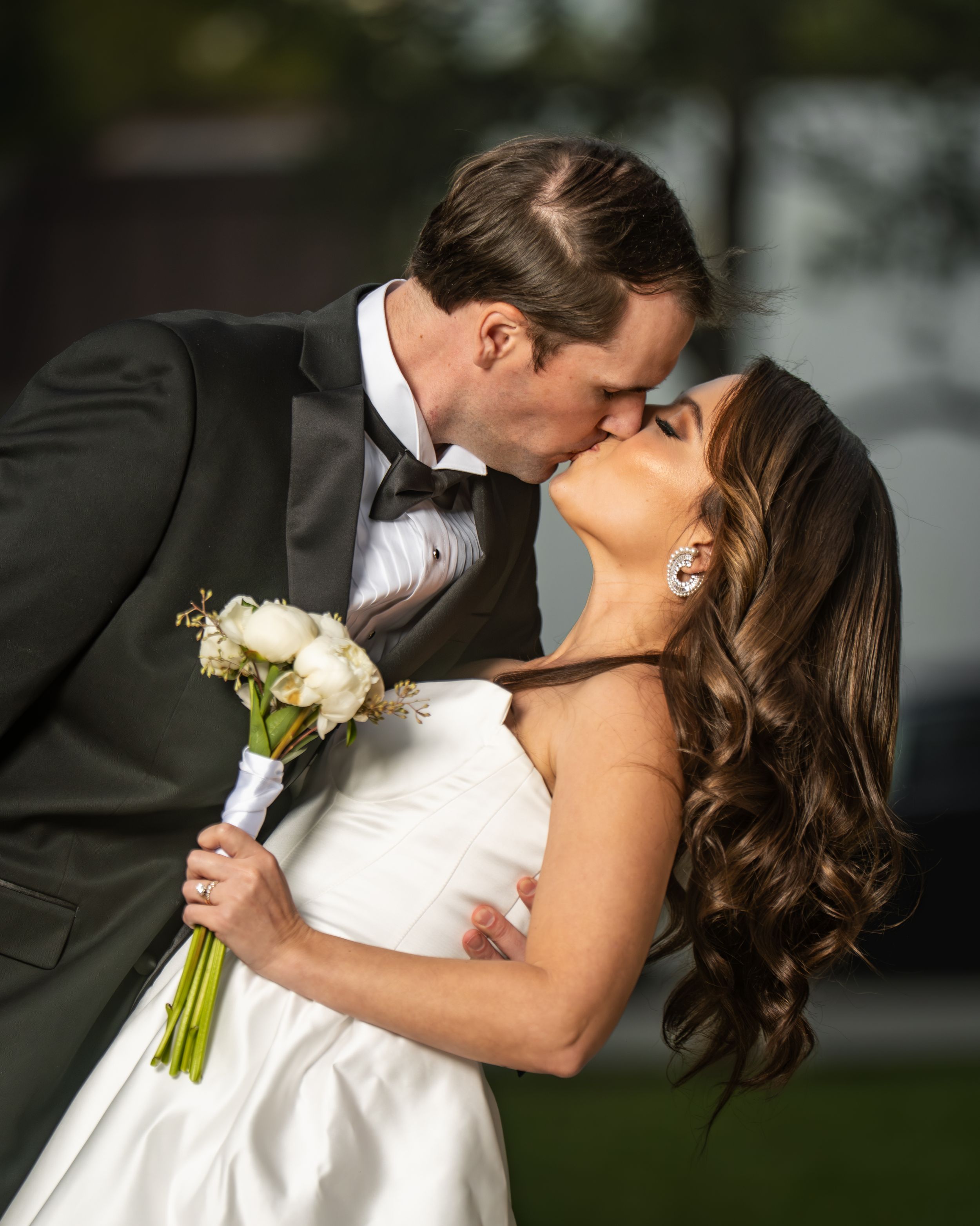A romantic wedding couple shares intimate kisses in a series of outdoor portrait photographs.