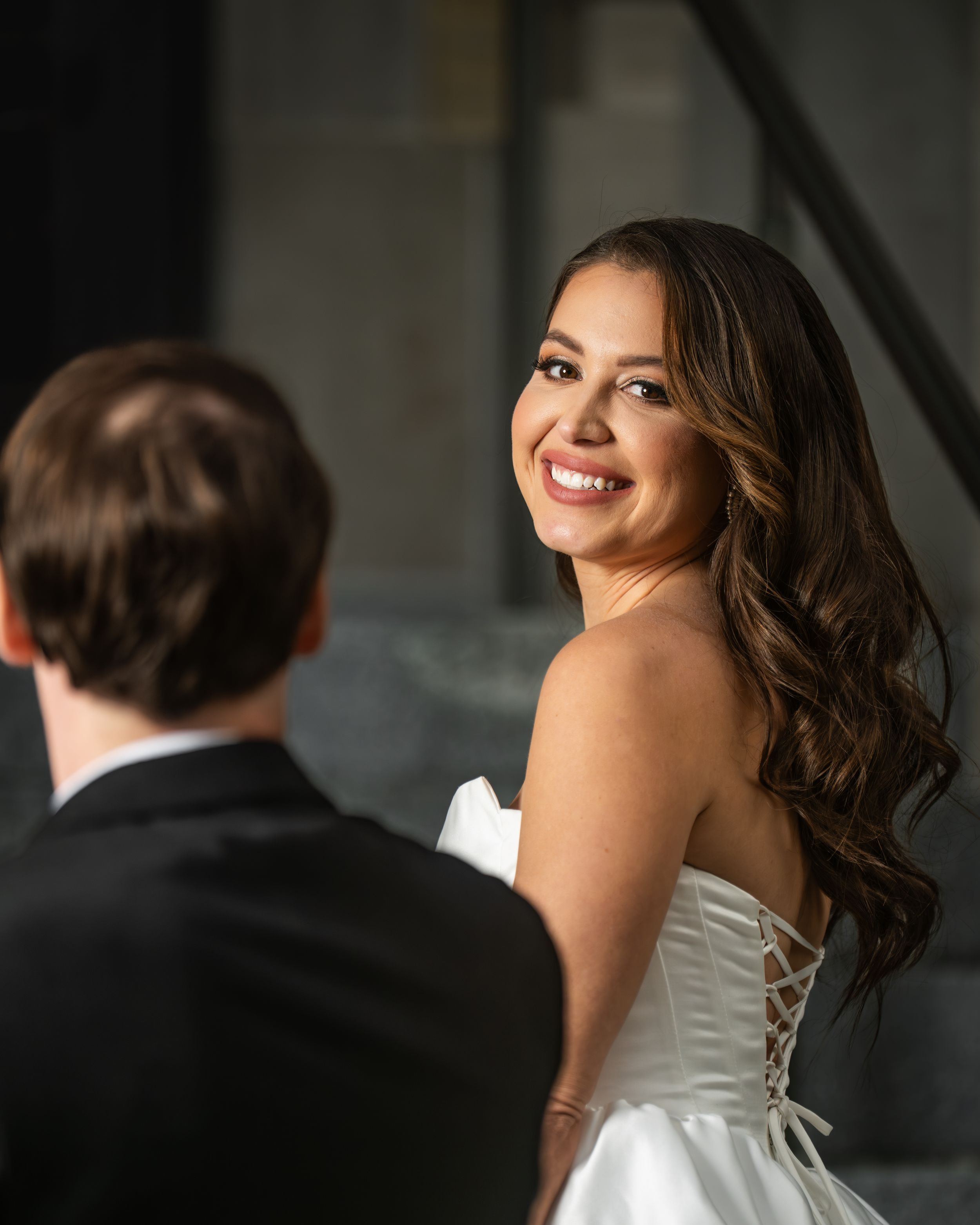 A couple shares an intimate moment during their wedding photoshoot with soft natural lighting creating a romantic atmosphere.