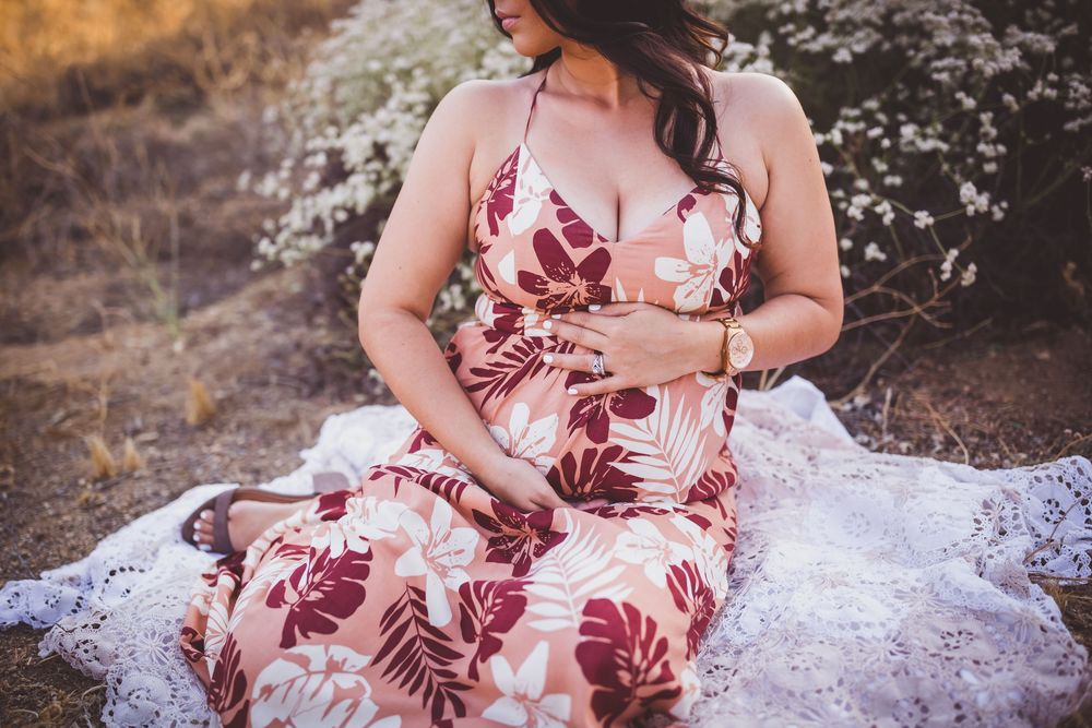 A romantic photoshoot featuring a floral dress and white lace details in a natural outdoor setting.