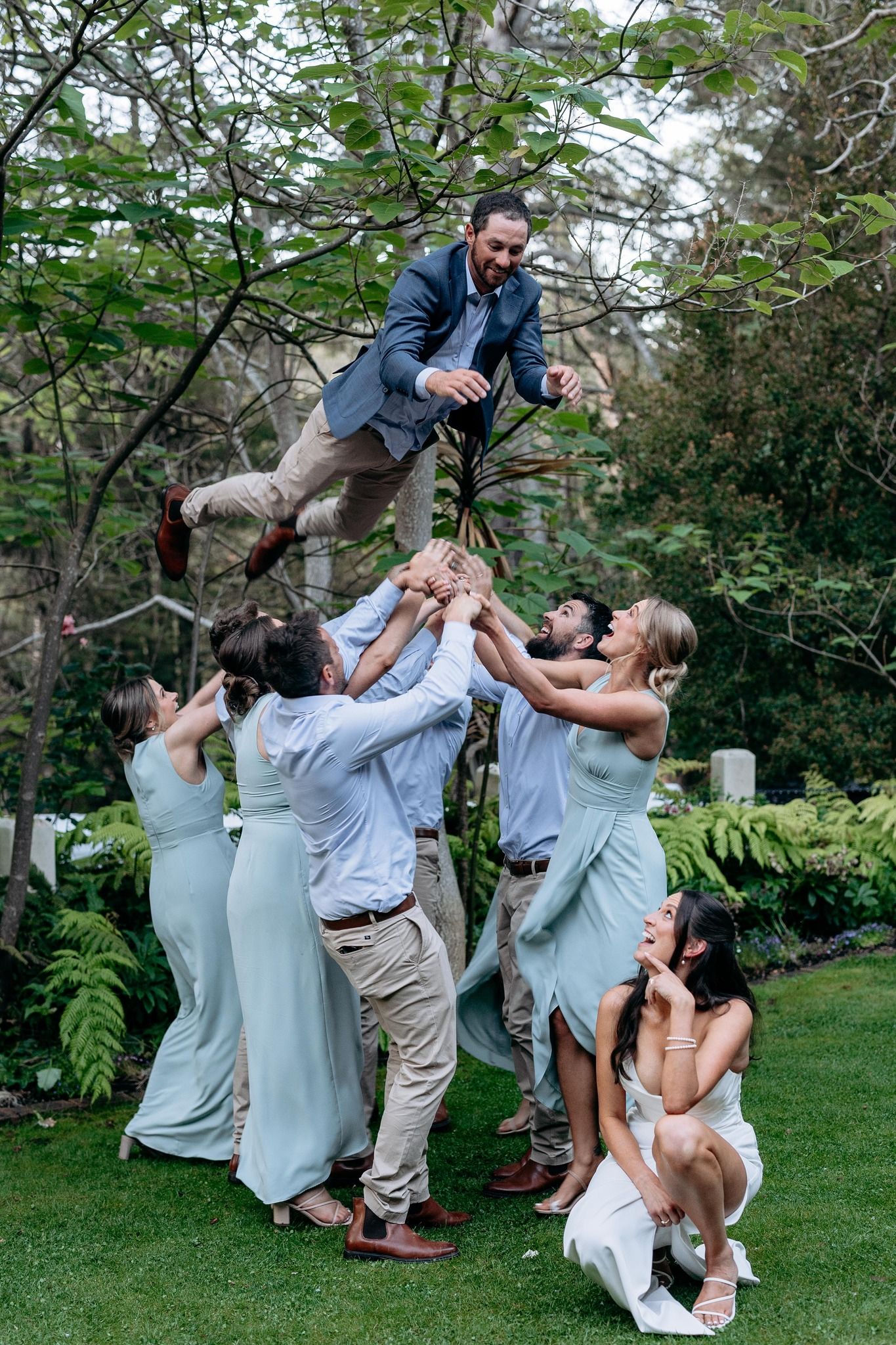 Groom being thrown into the air by wedding party while  bride looks on wedding photos by wedding photographer Serene Coleman