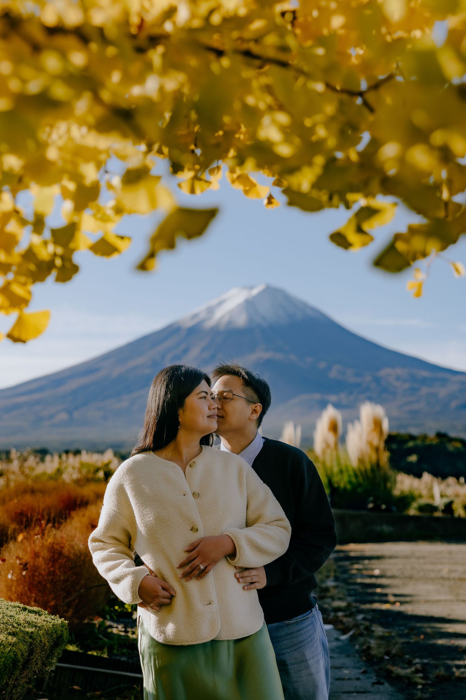 Scenic autumn landscape with Mount Fuji in Japan framed by golden ginkgo leaves during fall season.