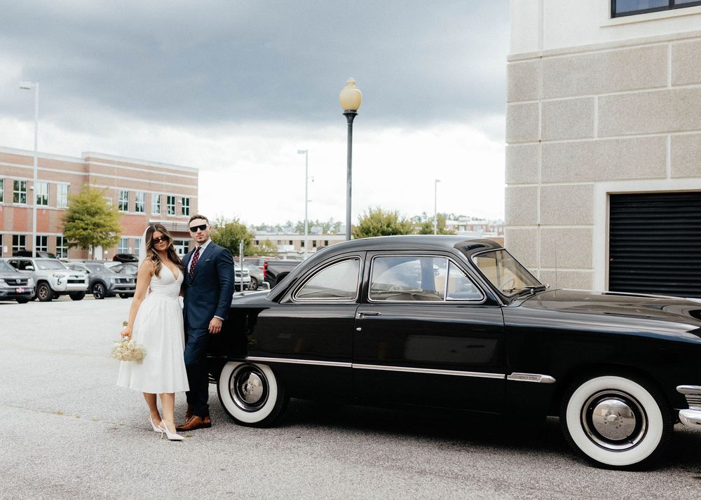 A classic black Lincoln Continental with white wall tires is displayed in multiple views at an outdoor location.