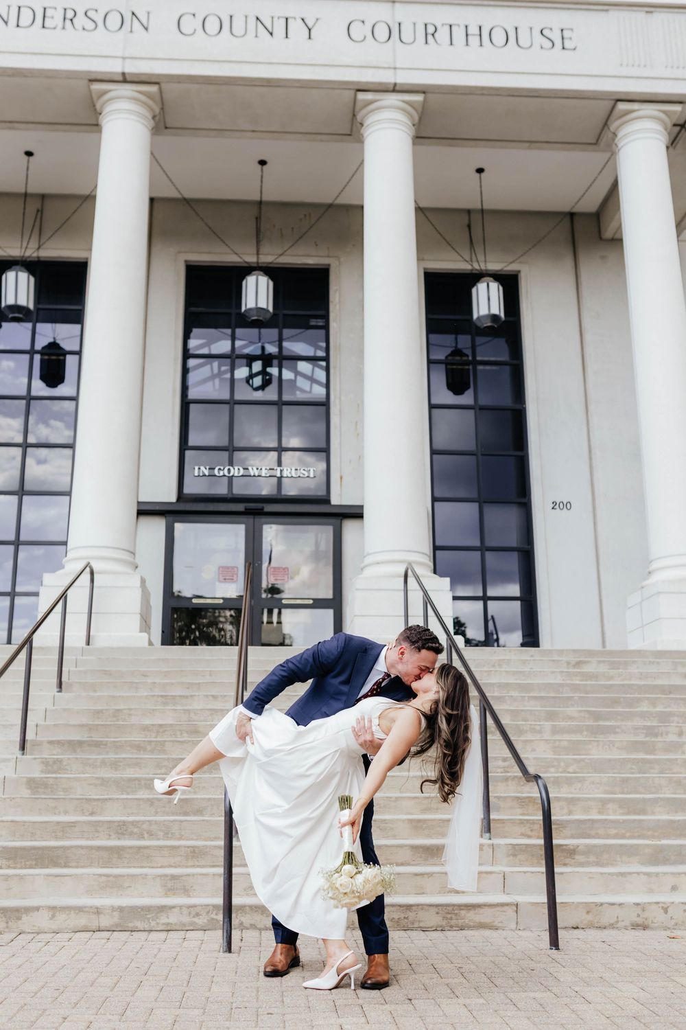 Romantic dance dip poses on the steps of Anderson County Courthouse with white columns.