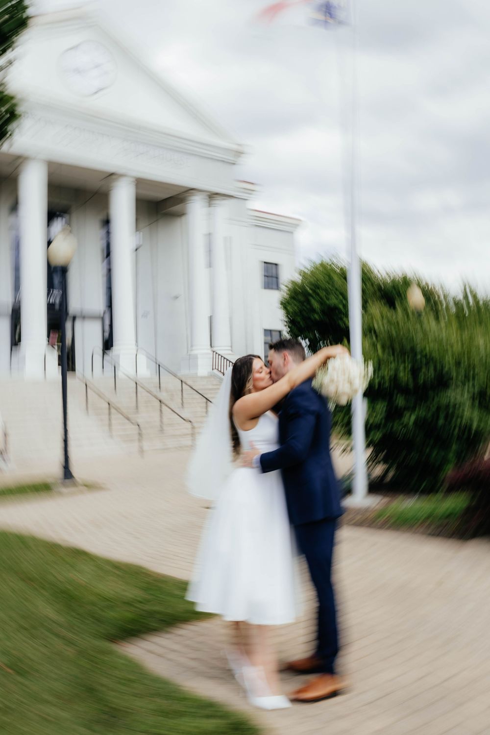 A sequence of motion-blurred wedding photos shows a couple dancing and spinning on an outdoor patio near white columns.