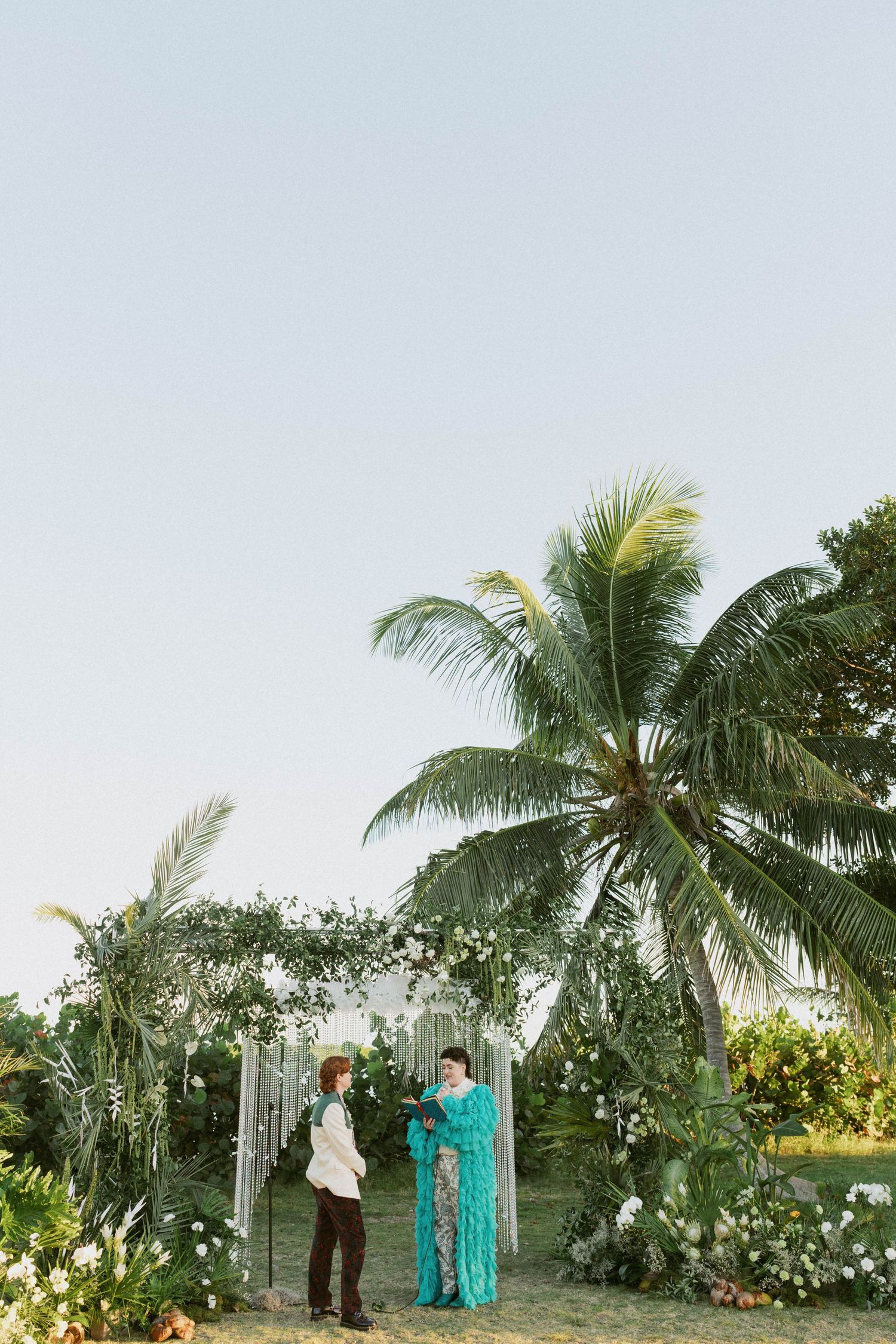 A sequence of four photos showing a bride and groom playfully peeking around white columns on a brick porch.