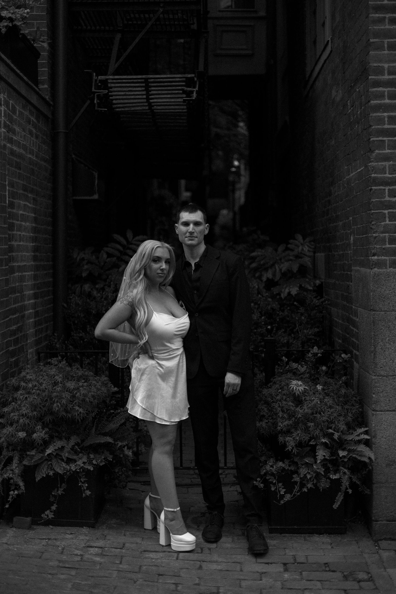 Two people dance together in a playful sequence of movements along a brick pathway.
