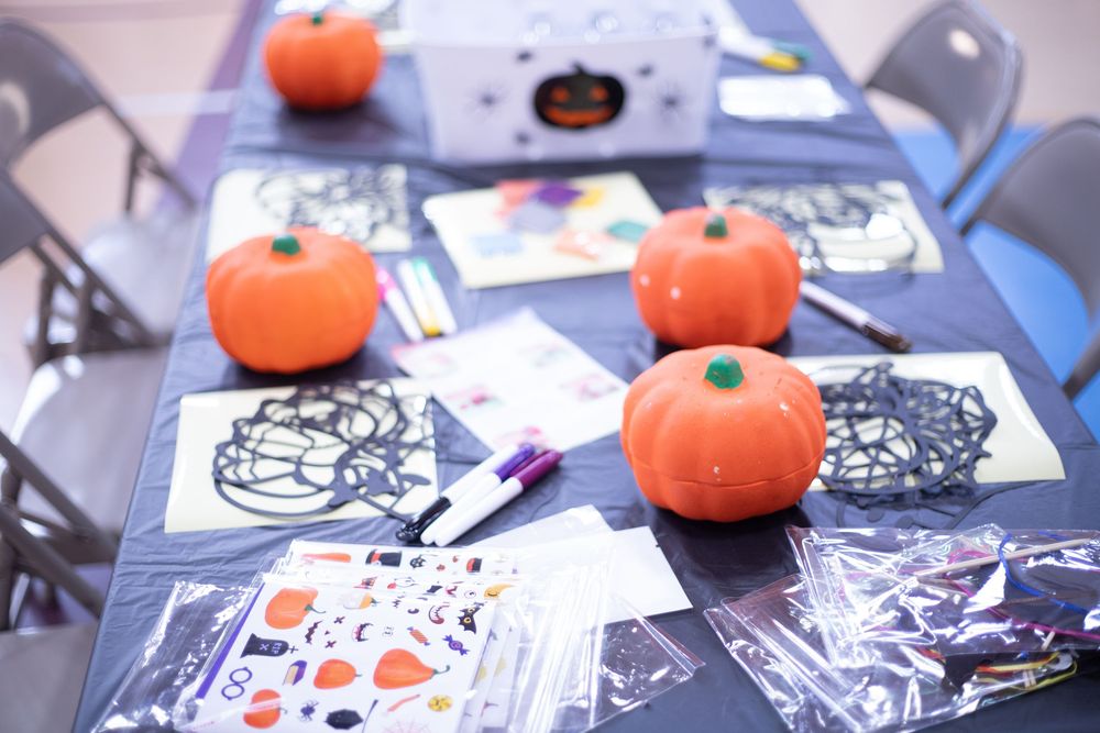 Orange pumpkins and Halloween decorations displayed on a table with black and white themed party supplies.