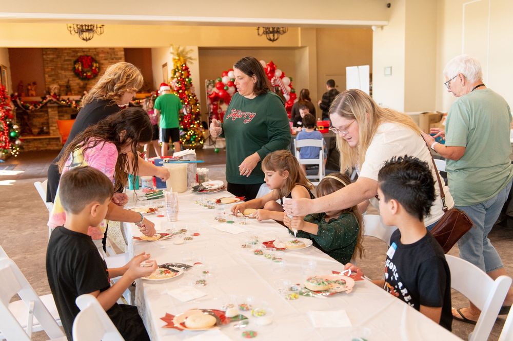 People gather around tables participating in a craft workshop or activity session in a community space.