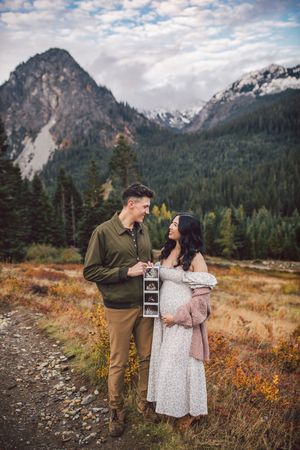 Couple standing together during their pregnancy announcement adventure photography session at Snoqualmie Pass near Seattle, Washington