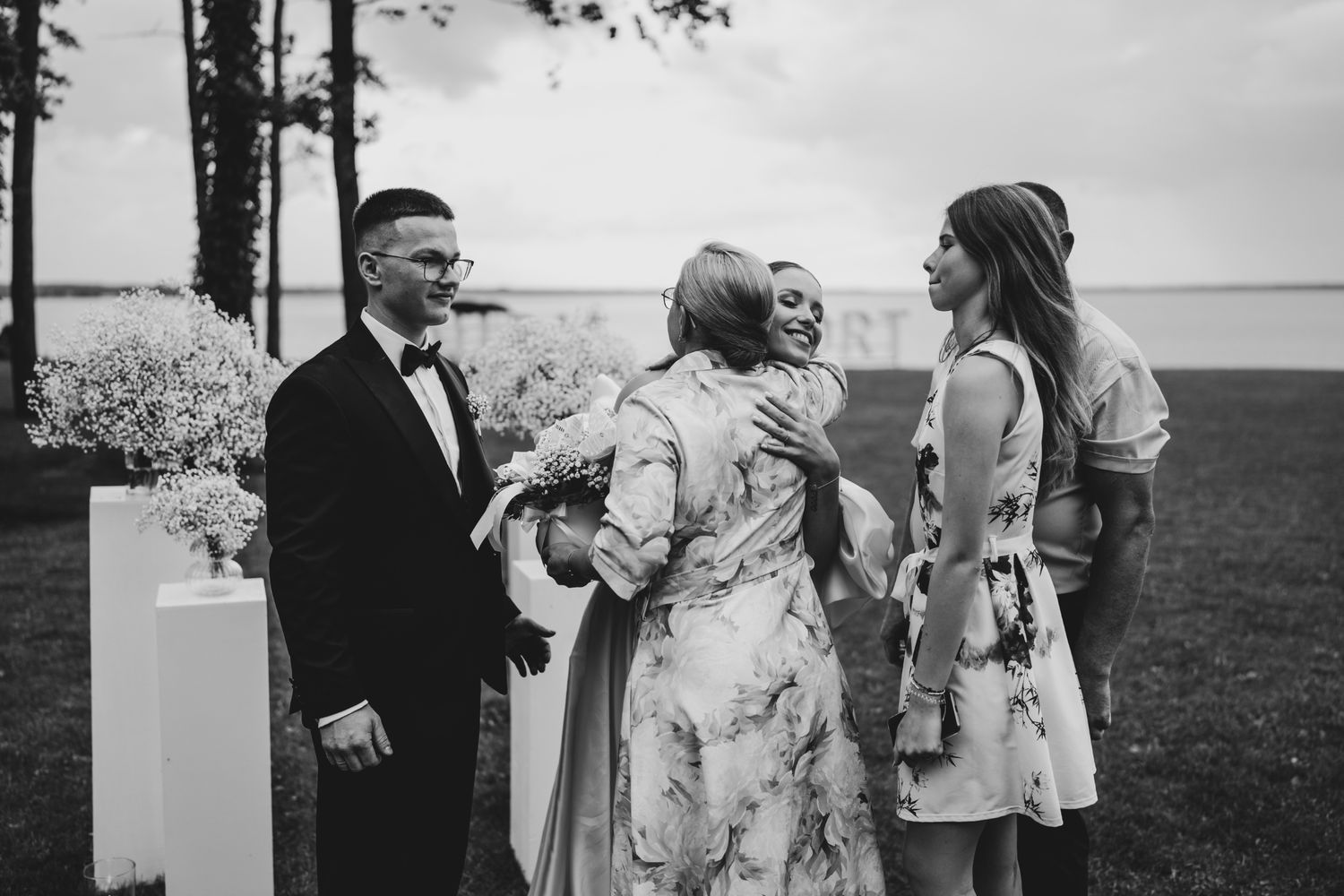 A group of wedding guests sharing an emotional moment during an outdoor celebration.