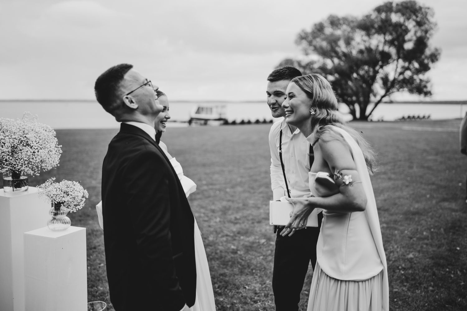 A candid moment of laughter shared between guests at an outdoor wedding reception.