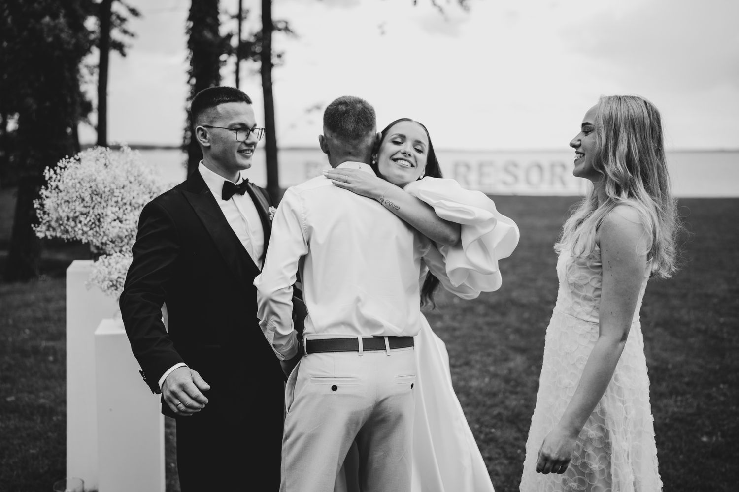 Joyful celebration between wedding guests during an outdoor ceremony.