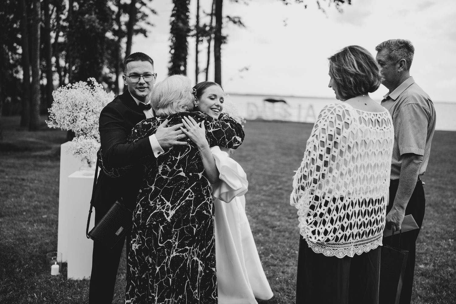 Emotional embraces shared between wedding guests at an outdoor gathering.